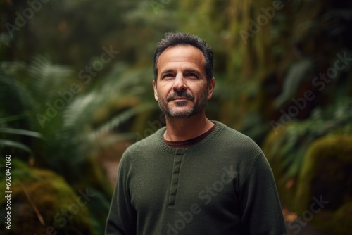 Portrait of a middle-aged man in a green t-shirt in the jungle