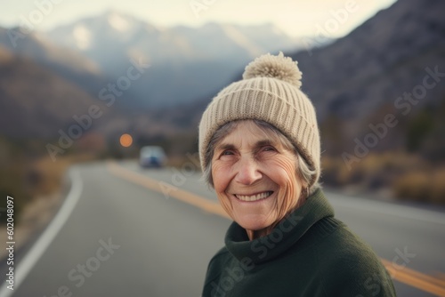 Portrait of a smiling senior woman standing on a road in the mountains