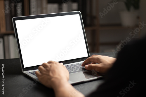 Fotografiet Mockup of man using and typing on laptop with blank white desktop screen