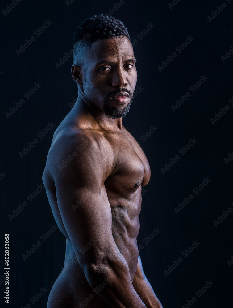 Handsome black male bodybuilder posing in studio shot, profile