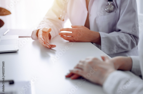Wallpaper Mural Doctor and patient sitting at the desk in clinic office. The focus is on female physician's hands reassuring woman, close up. Perfect medical service, empathy, and medicine concept Torontodigital.ca