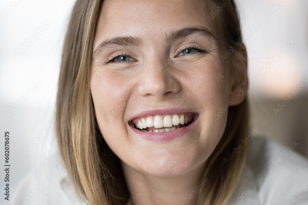 Happy beautiful young 20s girl looking at camera with toothy smile, promoting dental care, stomatology service, clinic, toothpaste. Close up cropped facial portrait of female model with white teeth Happy beautiful young 20s girl looking at camera with toothy smile, promoting dental care, stomatology service, clinic, toothpaste. Close up cropped facial portrait of female model with white teeth