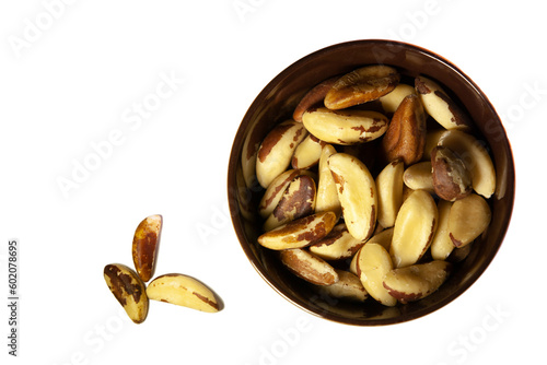 Obraz na płótnie Brazil nuts in a dark ceramic bowl. Top view. Isolated. w salonie