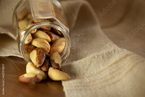 Obraz na płótnie Brazil nuts pouring out of the jar onto the table. Selective focus. w salonie