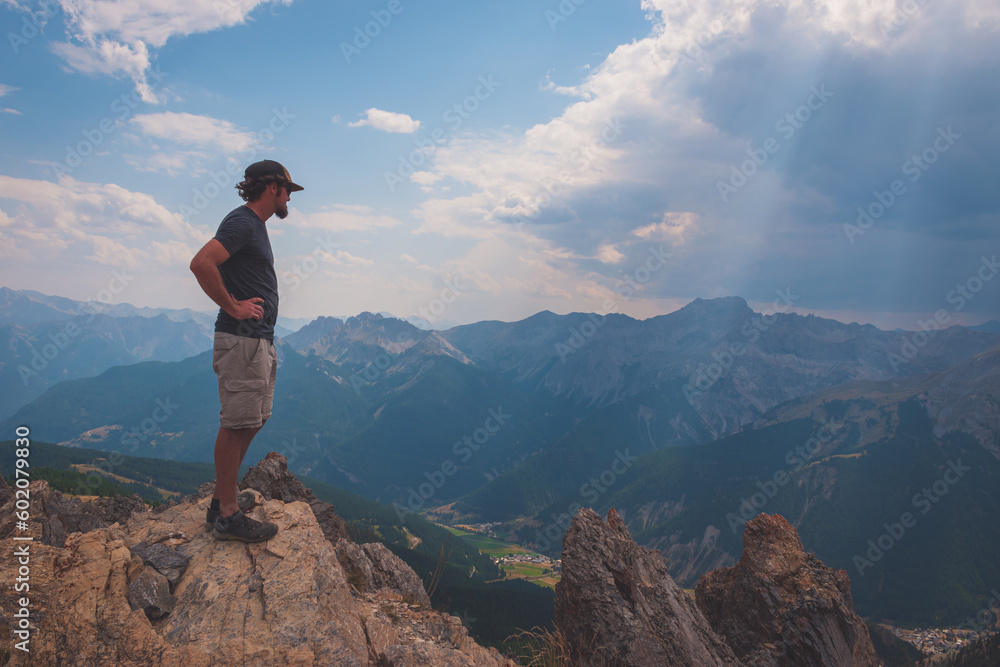 A male hiker standing on top of Sommet de Tronchet (Hautes-Alpes, France)