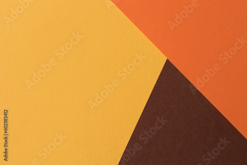 Orange and brown paper lies on the table, creating a geometric composition