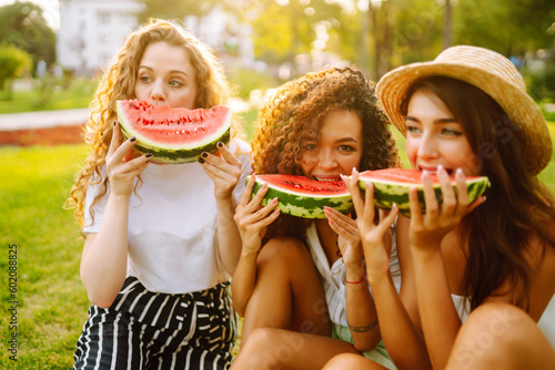 Three beautiful young girls have fun together and eating watermelon in hot day. Summer  lifestyle  travel  nature and vacations concept.