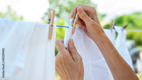 Tableau sur toile Woman hands hangs laundry on clothesline