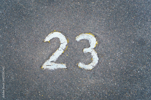 The number 23 written in white paint on the asphalt © Tatiana