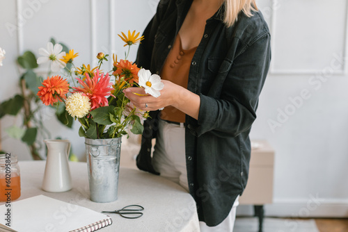 Close-up of a woman arranging flowers in a vase