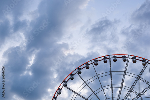 ferris wheel on a background of blue sky with clouds