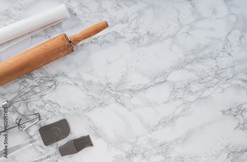 Cooking tools on a marble counter with space for lettering