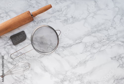 Cooking tools on a marble counter with space for lettering