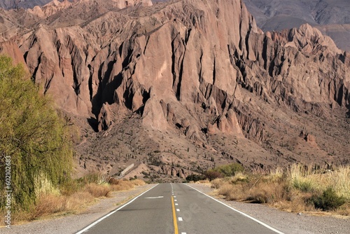 desert road leading to the red mountains of Salta in Argentina