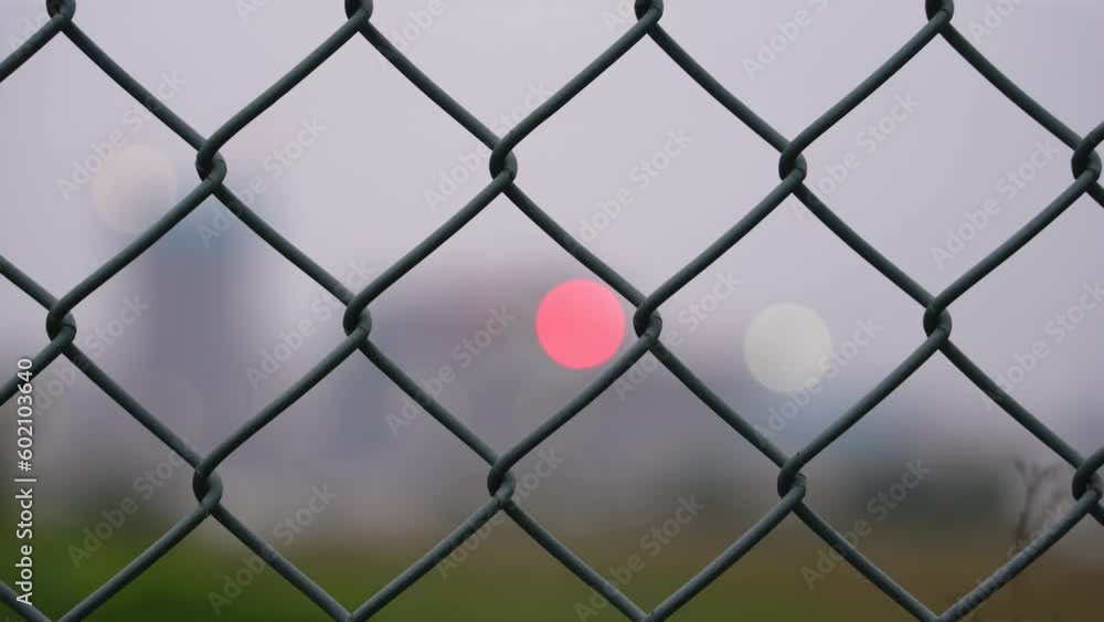 Woven wire fence with blur city view at night Woven wire fence with blur city view at night