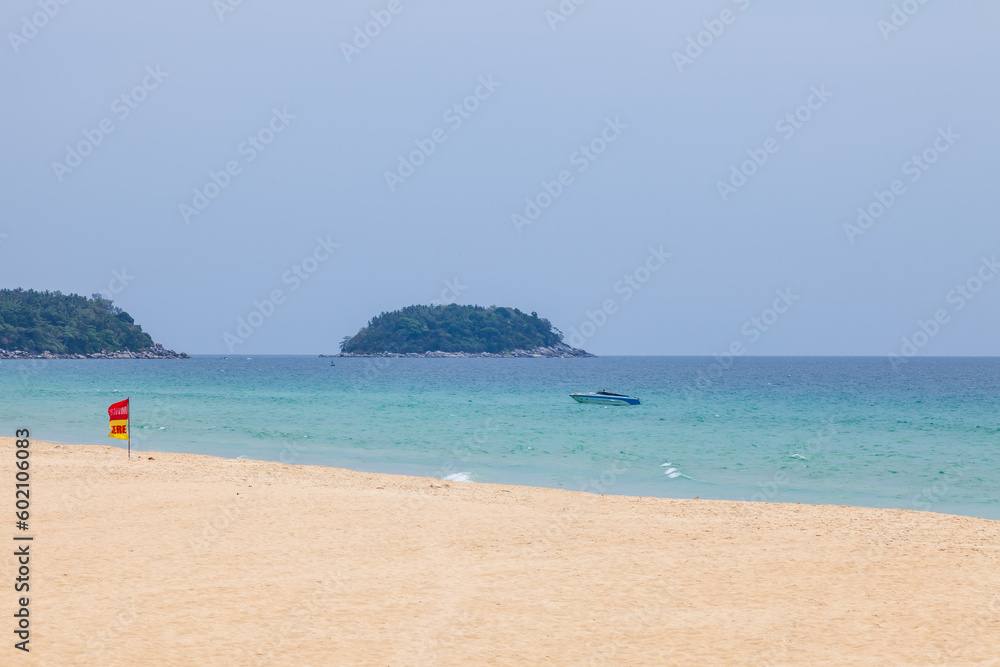 beautiful bright karon beach in thailand on phuket island with clear turquoise water in the sea, white sand with umbrella and blue sky. A popular tourist place in the hot countries of Asia. beautiful bright karon beach in thailand on phuket island with clear turquoise water in the sea, white sand with umbrella and blue sky. A popular tourist place in the hot countries of Asia.