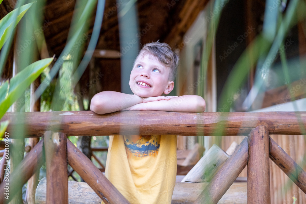 Obraz premium Young boy in tropical country day dreaming with a smile
