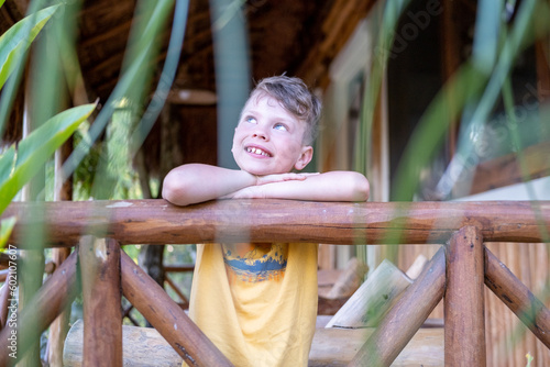 Young boy in tropical country day dreaming with a smile