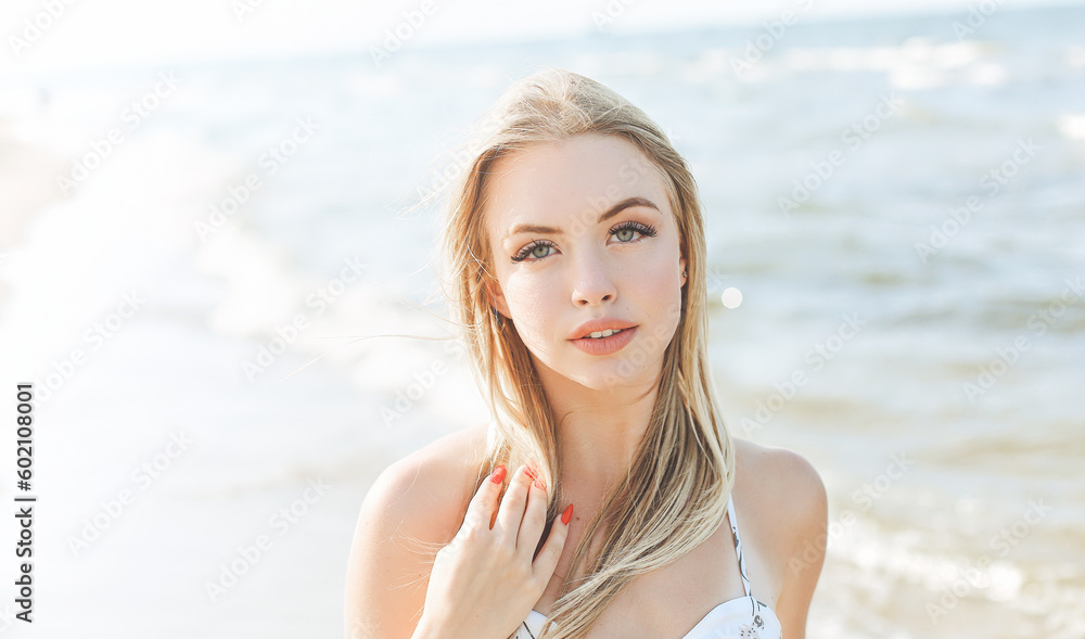 Happy blonde woman in free happiness bliss on ocean beach standing straight and posing