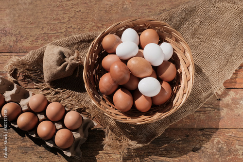 Beautiful brown colored eggs in a wooden basket in sunlight. Farmer's market, Egg price, increase. dietary product. Beautiful background with eggs.
