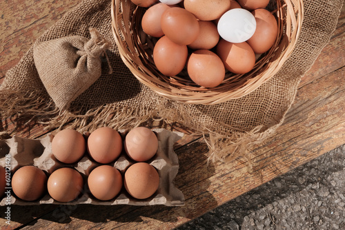 Brown eggs in a light wooden basket. Farm food product. Beautiful sunny background with eggs.