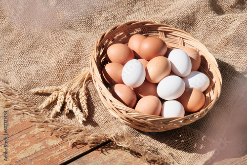 Beautiful brown colored eggs in a wooden basket in sunlight. Farmer's market, Egg price, increase. dietary product. Beautiful background with eggs.