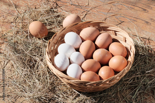 Brown eggs in a light wooden basket. Farm food product. Beautiful sunny background with eggs.