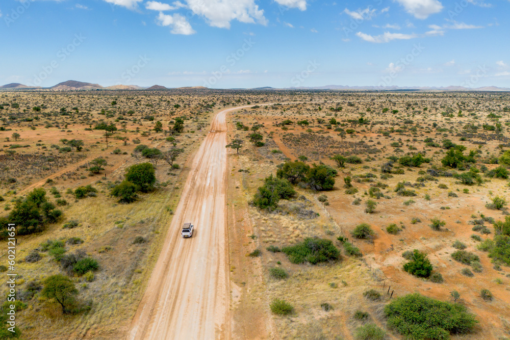 Drone image of off road vehicle driving on dirt road in Africa bush