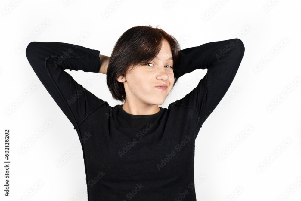 A teenage girl on a white background is happy and very positive, makes funny faces, girl is just happy because vacations and summer camps are coming soon A teenage girl on a white background is happy and very positive, makes funny faces, girl is just happy because vacations and summer camps are coming soon