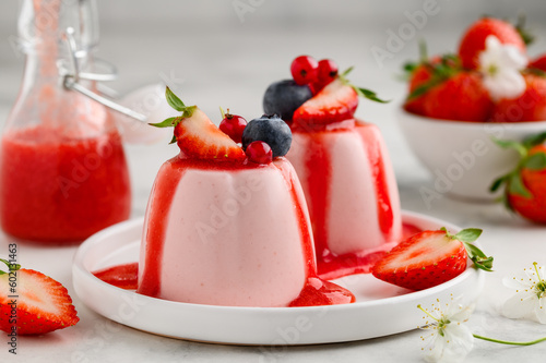 Obraz na plátně Strawberry panna cotta with berry sauce decorated with fresh berries on a white plate