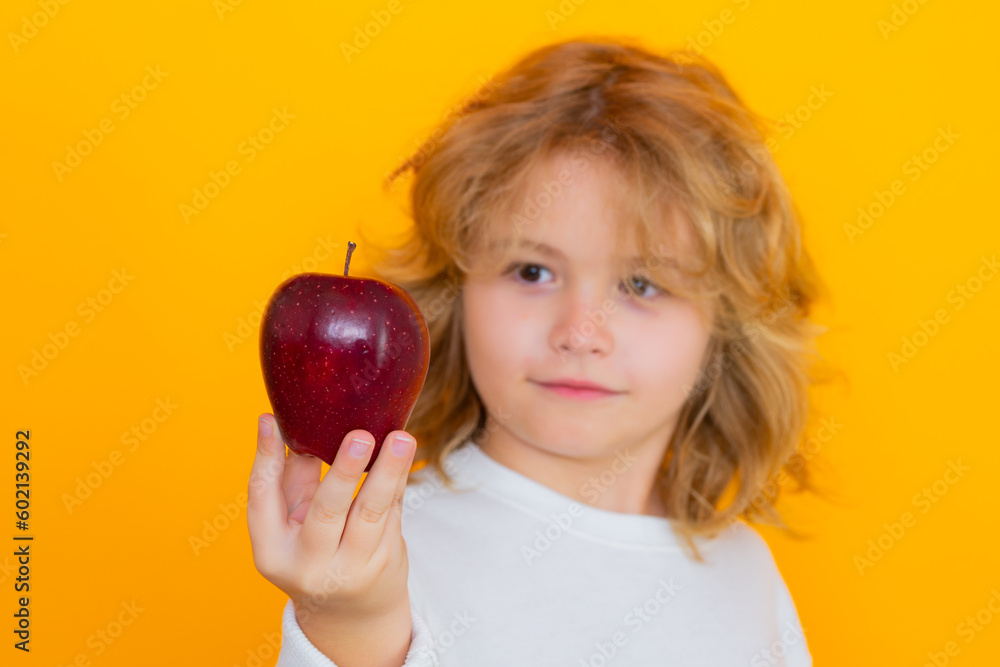 Kid with apple in studio. Studio portrait of cute child hold apple isolated on yellow background. Kid with apple in studio. Studio portrait of cute child hold apple isolated on yellow background.