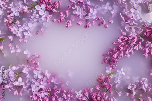 Branches of blossoming lilac float in milk. Copy space  flat lay. The concept of purity  tenderness  freshness  youth. Summer mood.