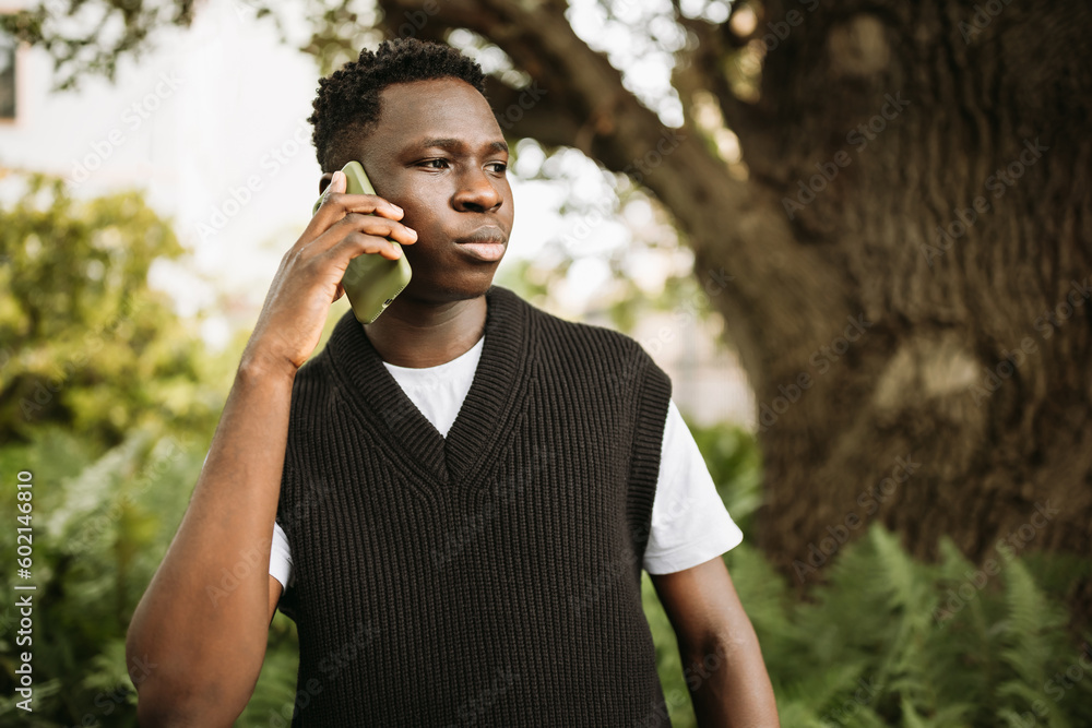 Young African man talking on phone shocked, stressed, unsatisfied Young African man talking on phone shocked, stressed, unsatisfied