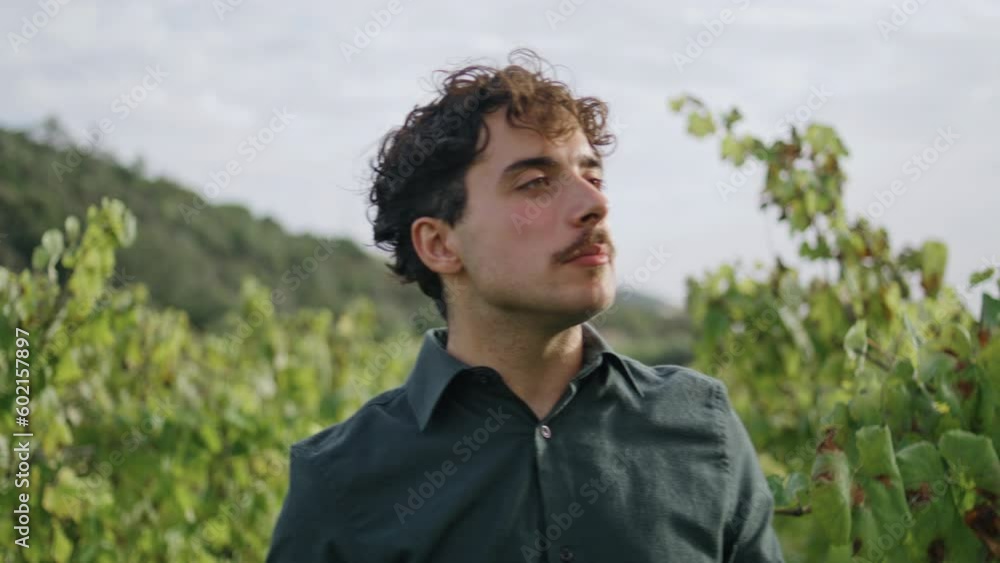 Winegrower eating ripe grapes at plantation close up. Young man tasting harvest. Winegrower eating ripe grapes at plantation close up. Young man tasting harvest.