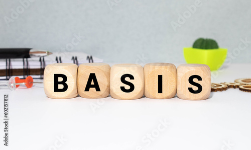 White tile alphabet letter with word basis on wood background.