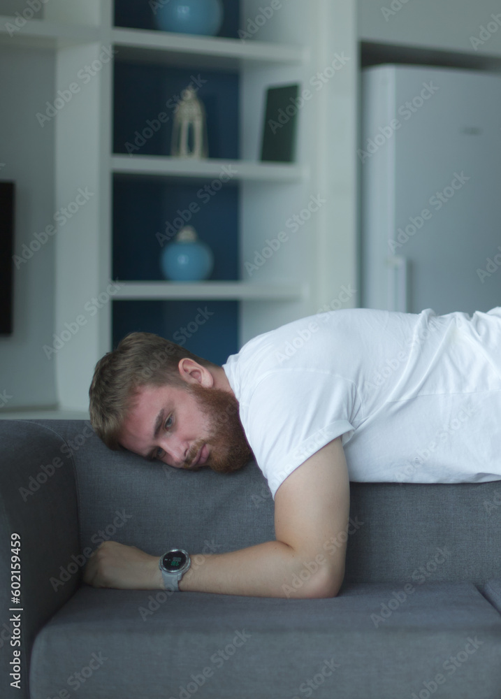 Exhausted young man fell asleep on comfortable couch in modern living room, having no energy after hard working day. Tired depressed unmotivated european guy napping on sofa at home, fatigue concept. Exhausted young man fell asleep on comfortable couch in modern living room, having no energy after hard working day. Tired depressed unmotivated european guy napping on sofa at home, fatigue concept.