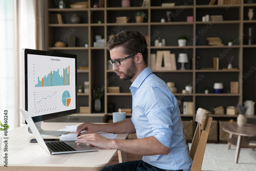 Obraz na plátně Focused young freelance business man analyzing financial data on desktop large d