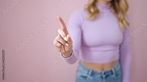 Young beautiful hispanic woman saying no with finger over isolated pink background photo