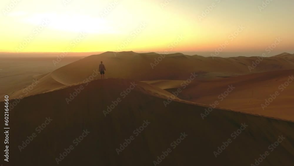 Travel, desert and silhouette of man at sunset for freedom, destination and Namibia landscape. Adventure, abroad and trip with guy walking on horizon of sand dunes for journey, vacation and summer Travel, desert and silhouette of man at sunset for freedom, destination and Namibia landscape. Adventure, abroad and trip with guy walking on horizon of sand dunes for journey, vacation and summer