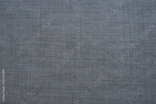 Fabric texture background. Gray fabric with weave. Natural slightly wrinkled look of the material. Uniform copy space background. Cotton, canvas or woolen thin fabric laid evenly on the surface.