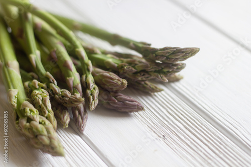 Green asparagus on white wooden background