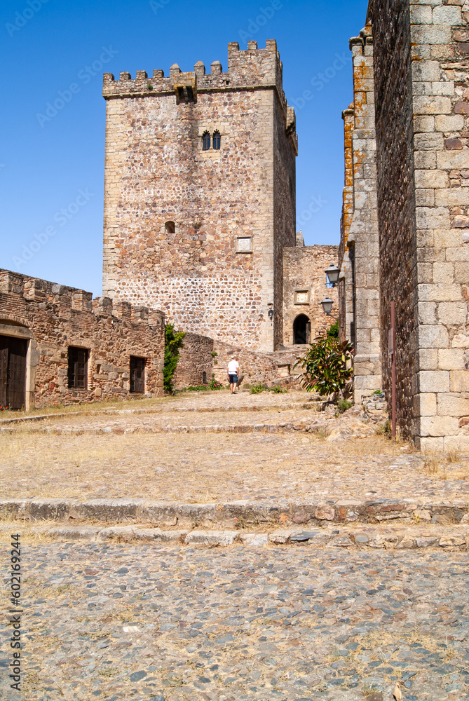 Turista de vacaciones visitando el patio de armas de un antiguo castillo medieval.
