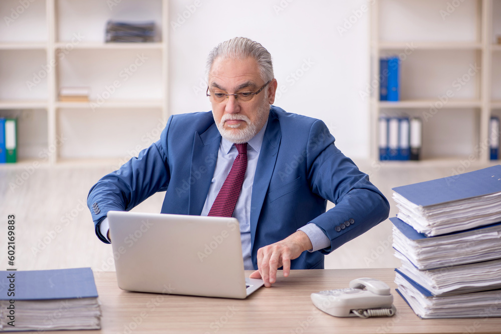 Old male employee and too much work at workplace Old male employee and too much work at workplace