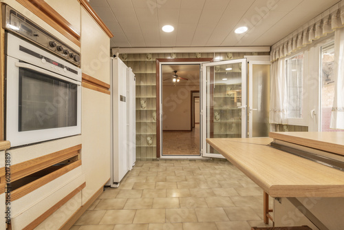 A kitchen full of light colored column cabinets with wooden bevels and moldings