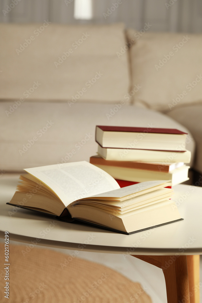 Many different books on white table indoors Many different books on white table indoors