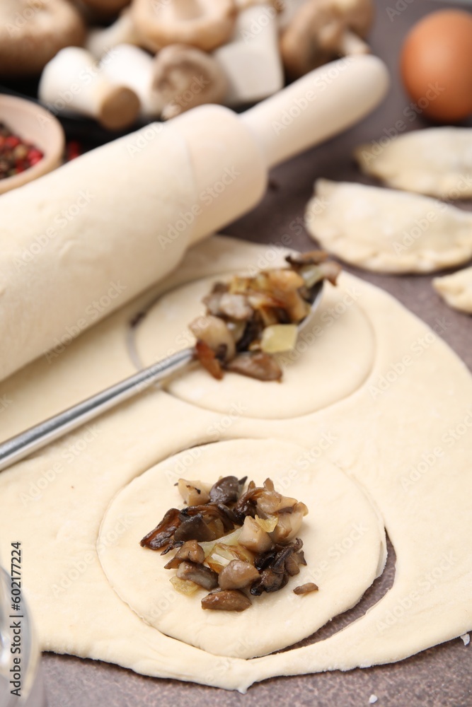 Process of making dumplings (varenyky) with mushrooms. Raw dough and ingredients on grey table, closeup Process of making dumplings (varenyky) with mushrooms. Raw dough and ingredients on grey table, closeup