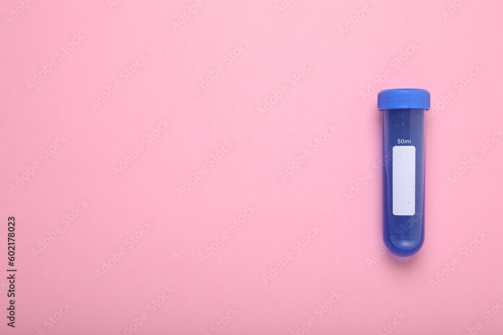Test tube with liquid on pink background, top view and space for text. Kids chemical experiment toy Test tube with liquid on pink background, top view and space for text. Kids chemical experiment toy