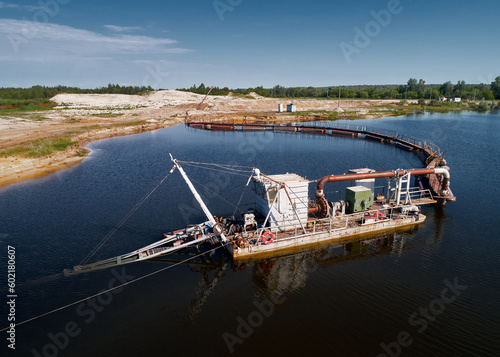 Foto Trailing suction hopper dredger draws up bottom mud on river