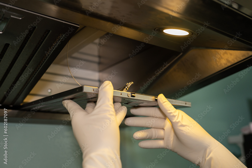 Someone hands trying to removing a filters from cooker hood for