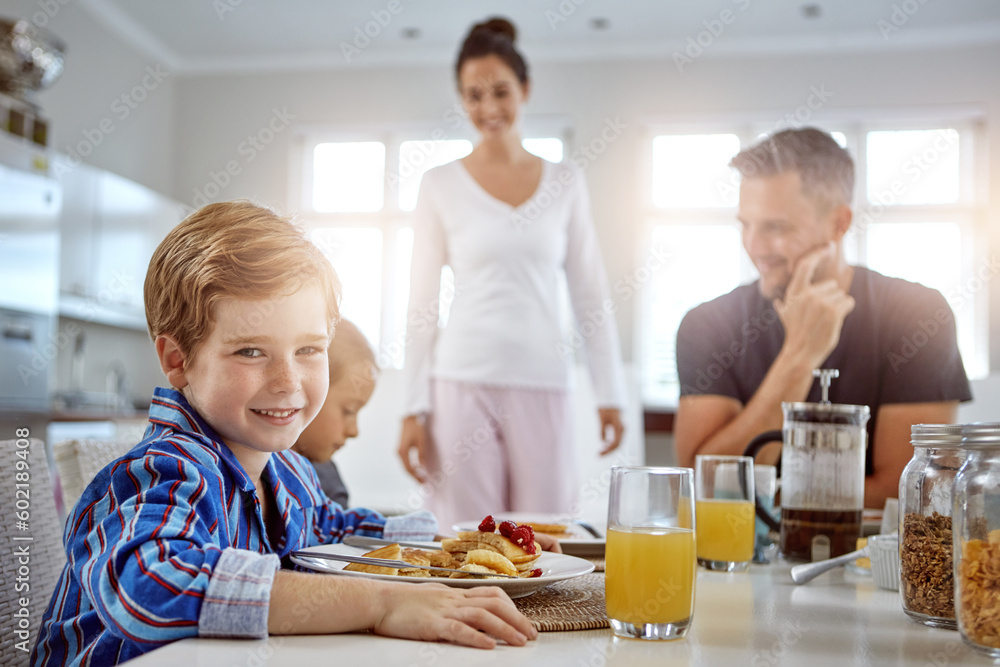 Child, portrait and pancakes for breakfast in a family home with love, care and happiness at a table. A happy woman, man and kids eating food together in morning for health, happiness and wellness